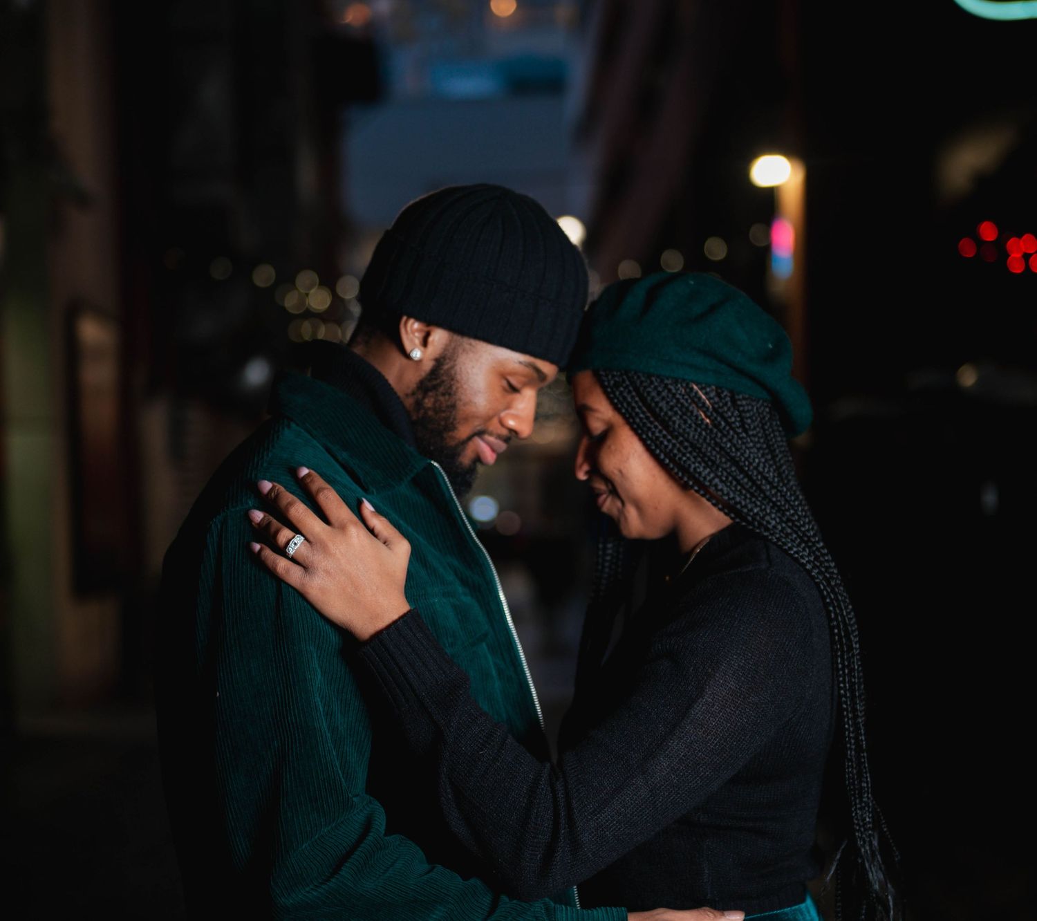 An intimate nighttime portrait of a couple in winter clothing sharing a close moment.