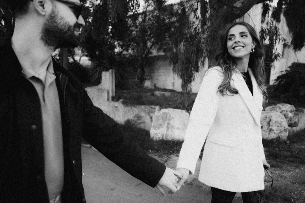 A series of black and white candid wedding photos showing intimate moments between couples during an outdoor ceremony.