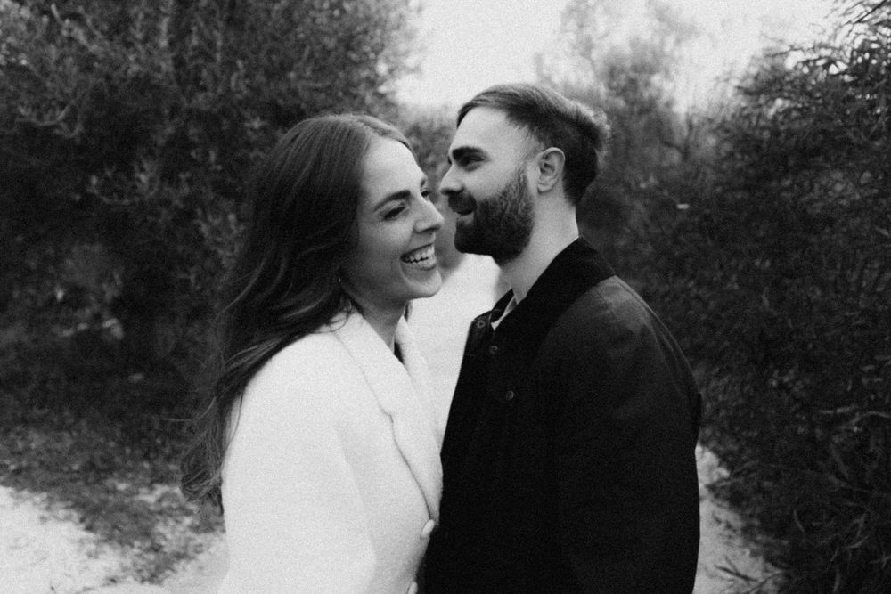 A romantic black and white photo series showing intimate moments between a couple in a garden setting.