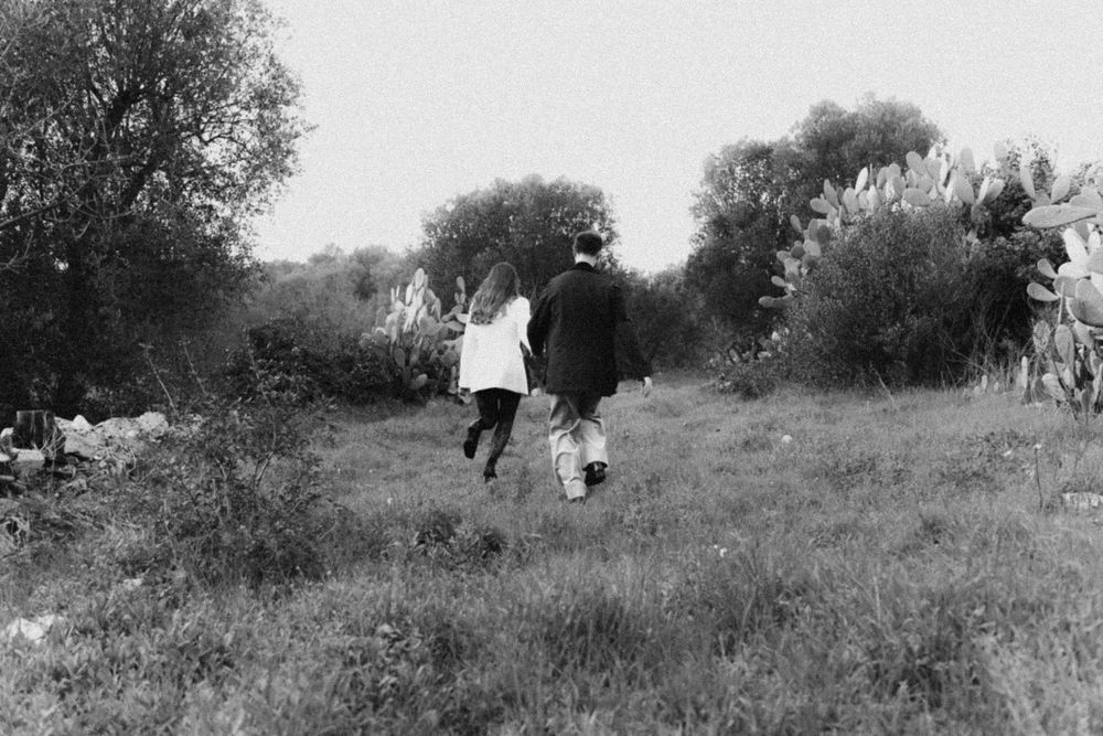 A couple sharing an intimate moment outdoors in a natural setting.