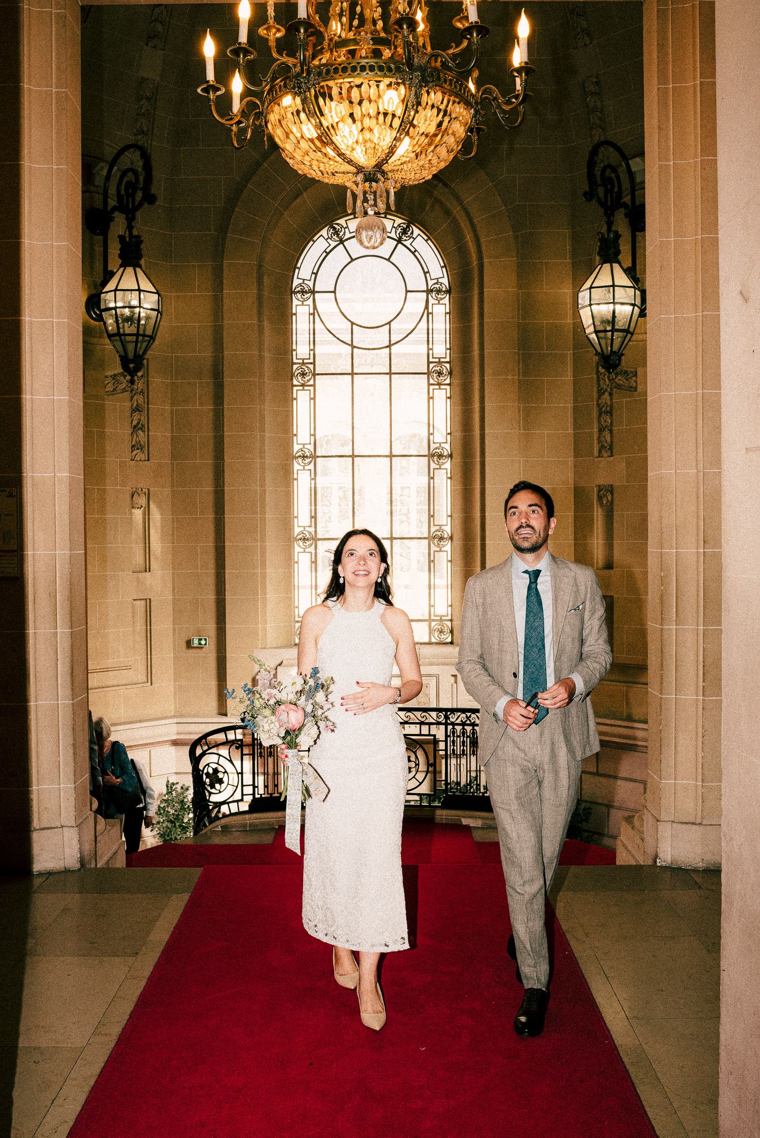 A wedding couple shares a joyful moment dancing together while surrounded by guests at their reception celebration.