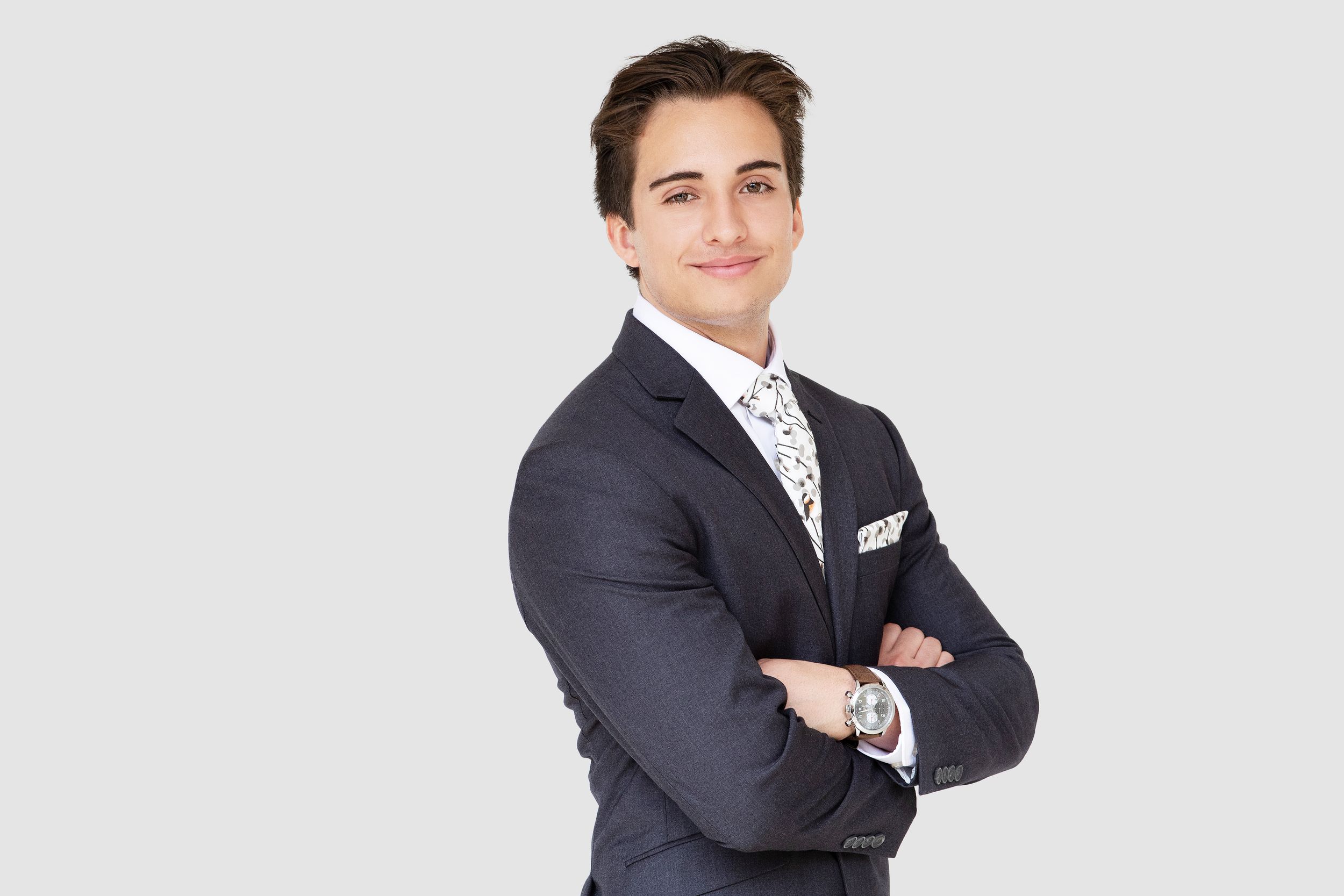 Corporate headshot of a realtor, arms crossed with confident smile