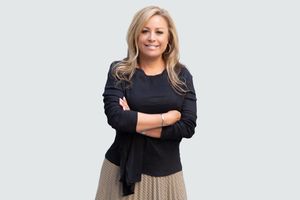 Individual realtor portrait: smiling professional real estate agent in studio lighting