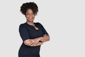 Individual realtor portrait: smiling professional real estate agent in studio lighting