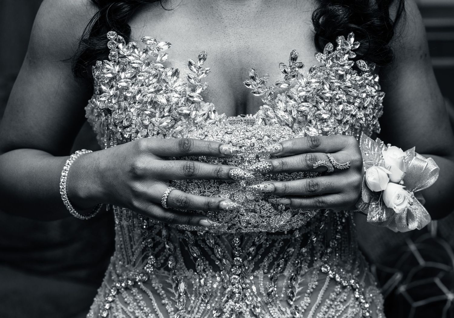 Close-up of intricate beaded wedding dress bodice with crystal details and wrist corsage.