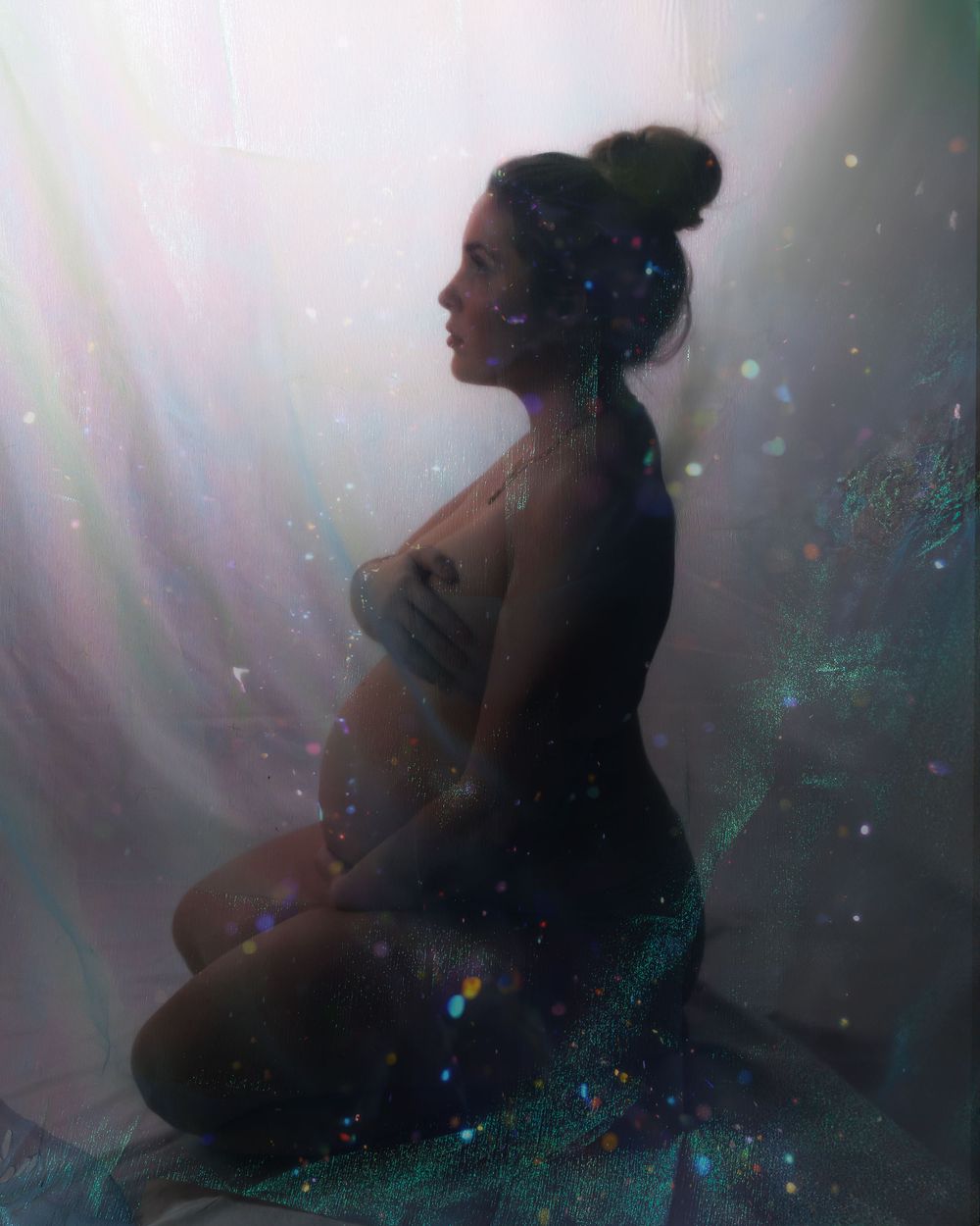 A silhouetted figure sits in a dreamy underwater atmosphere with ethereal light rays and sparkling particles.