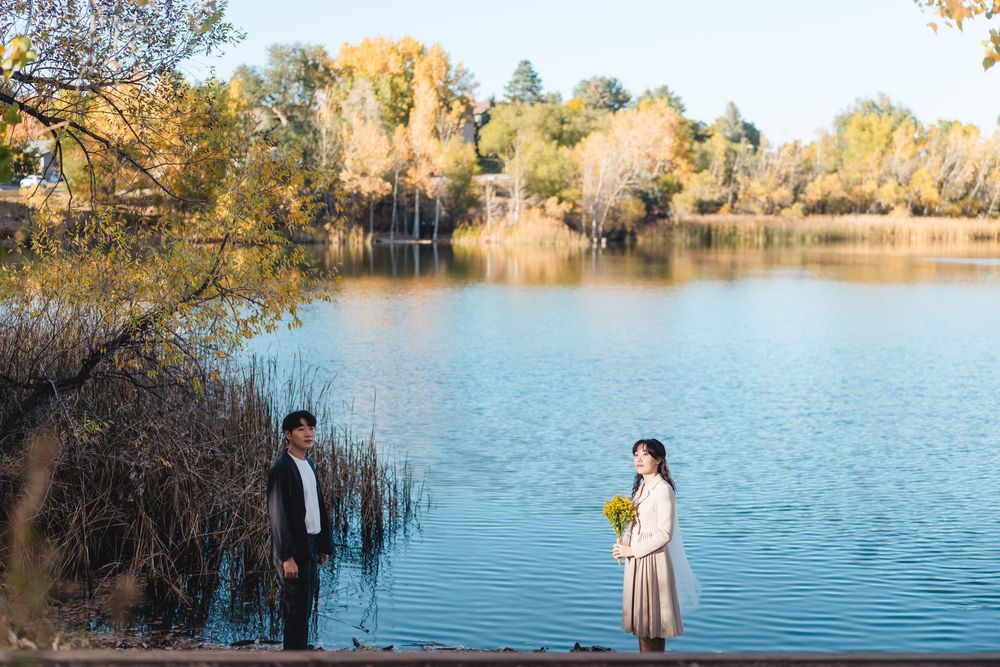 A serene lakeside photo series showing people enjoying autumn reflections on calm blue water surrounded by golden trees.