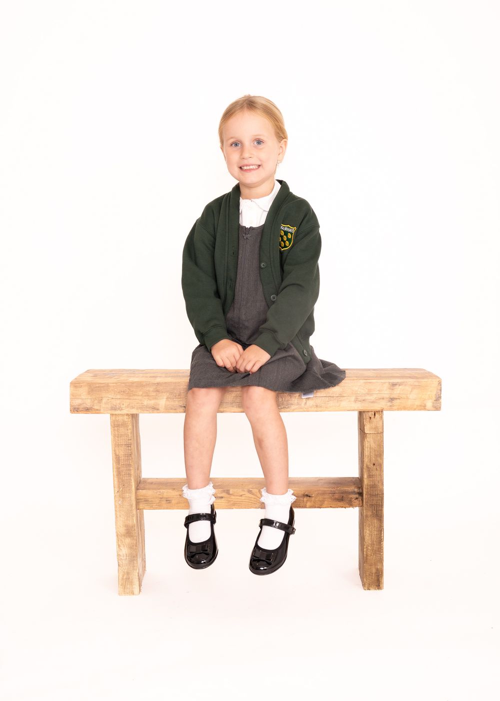 Child wearing a green school uniform sits at different positions on a wooden bench in a composite photo sequence.