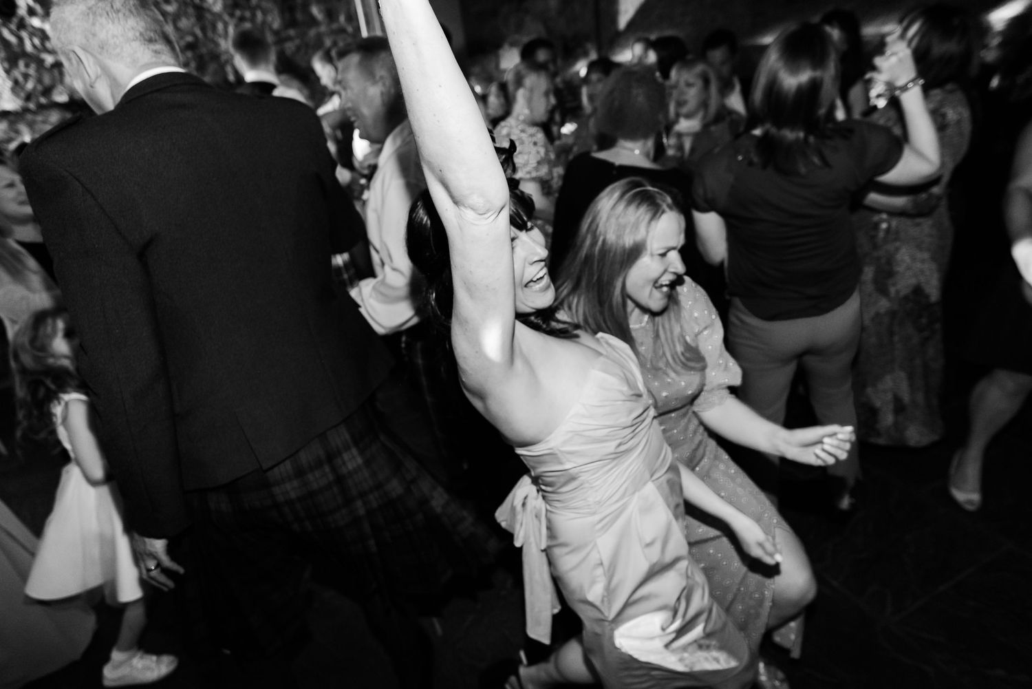 Energetic dancing captured in black and white photography at a celebratory event.
