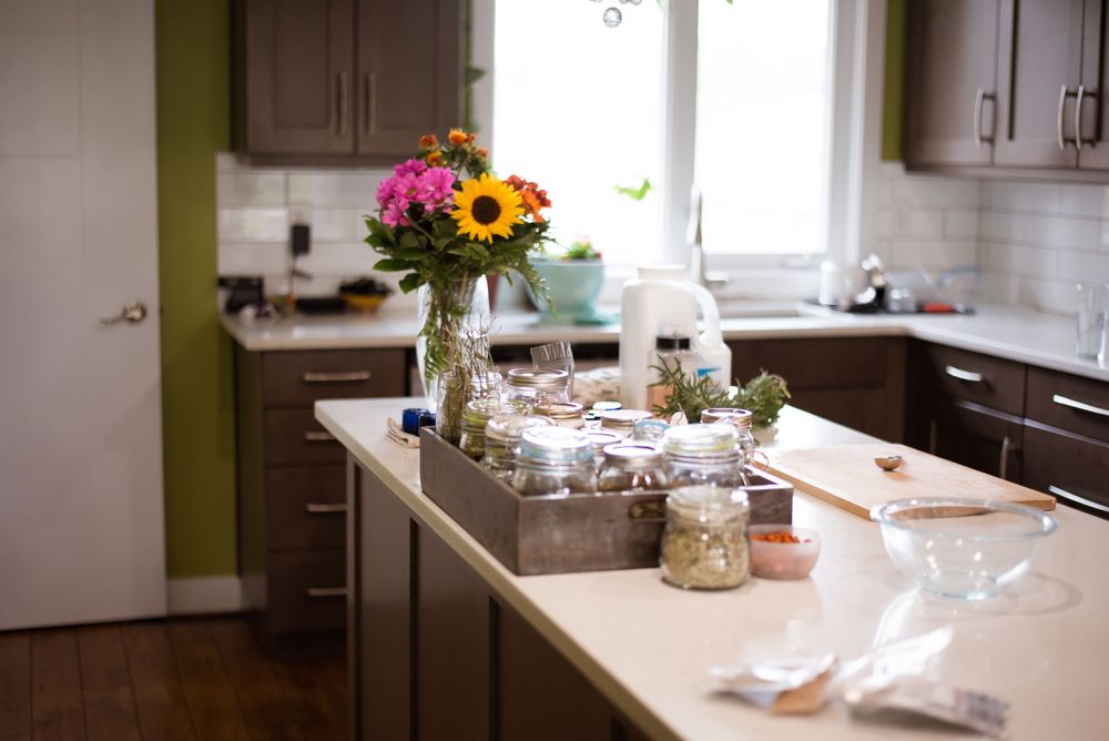 Bright sunflower bouquet and tea set on modern white kitchen counter.
