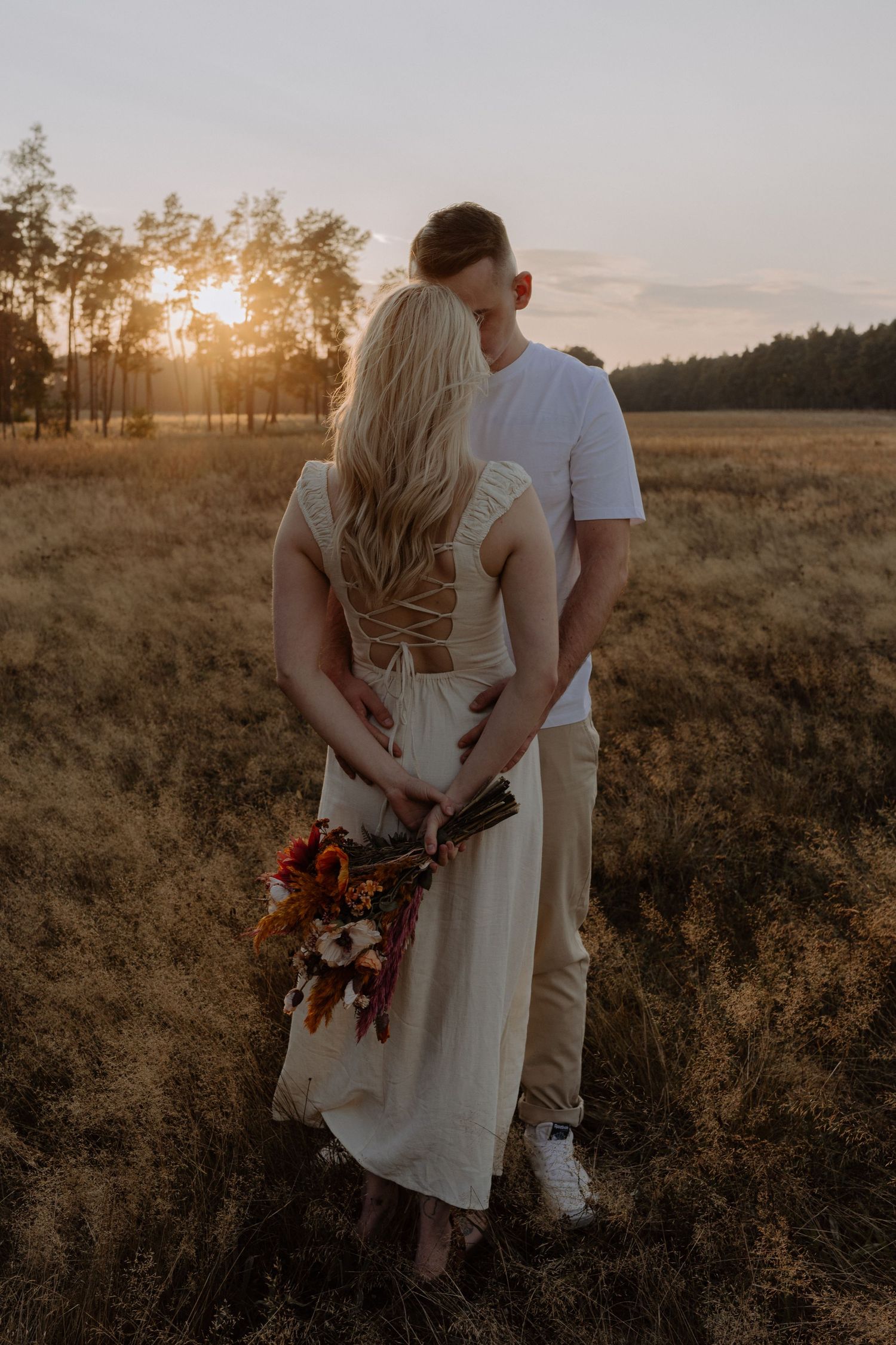 A romantic sunset scene in a golden field with autumn flowers.