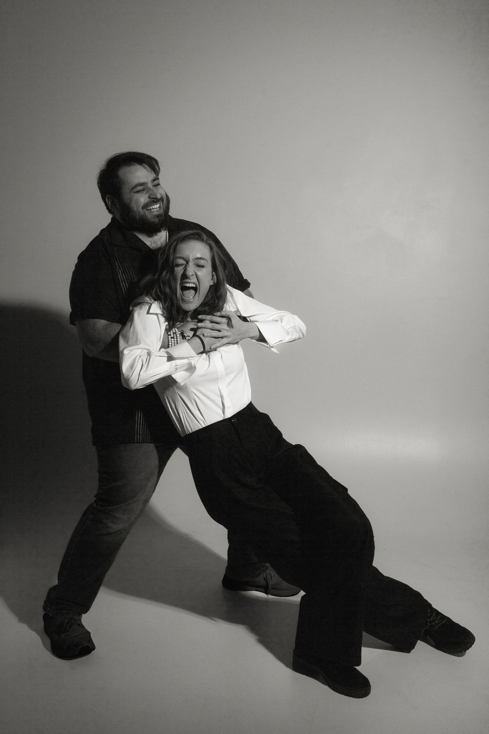 Playful black and white studio portrait capturing a dynamic dancing moment.