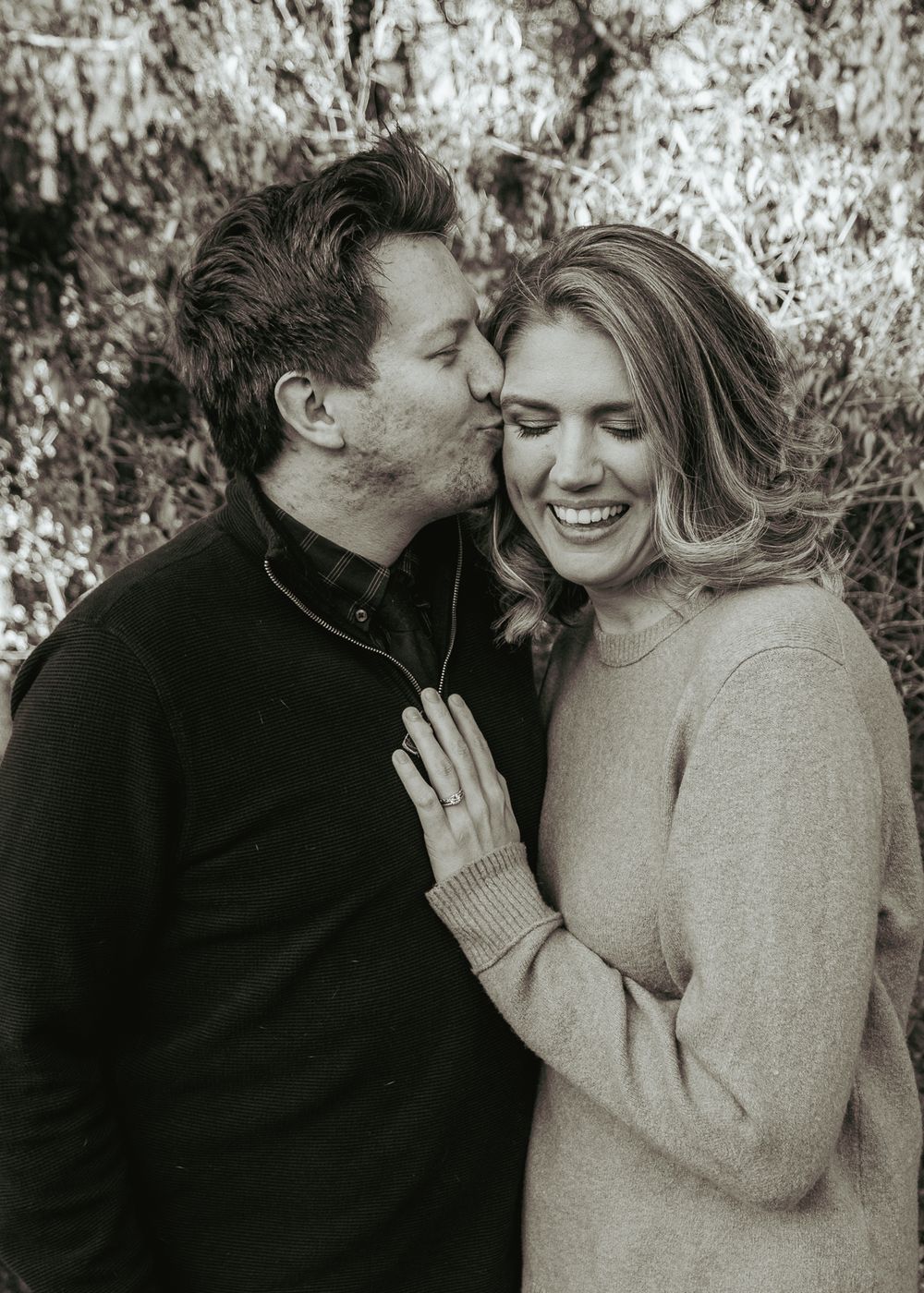 Intimate black and white portrait of couple sharing tender moment.