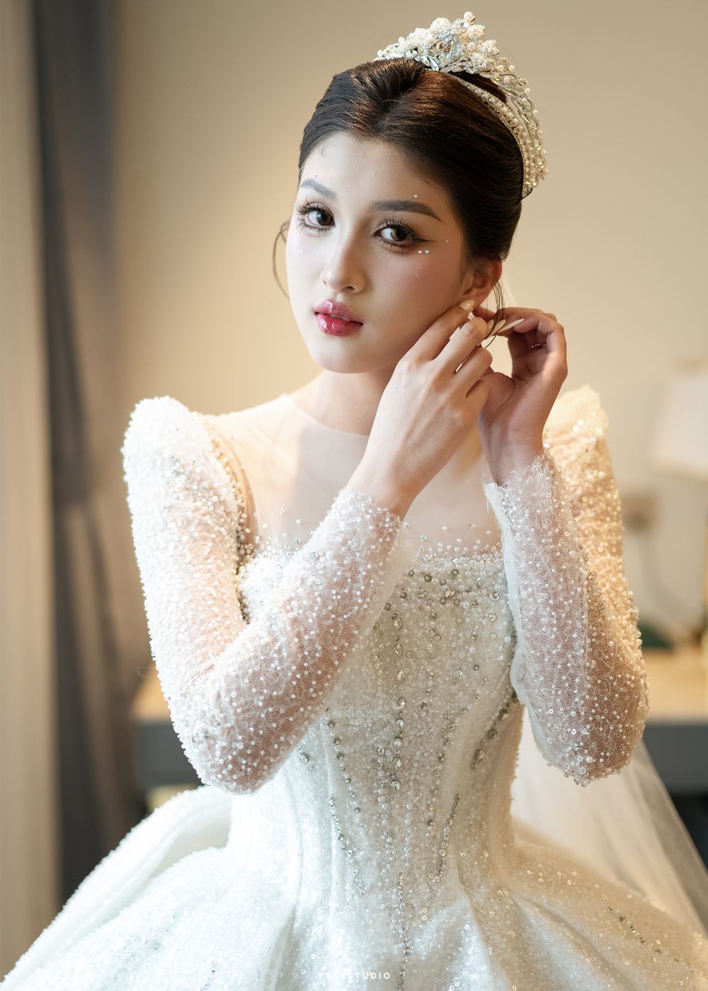 Elegant bridal portrait featuring a sparkly long-sleeved ballgown and crystal crown.