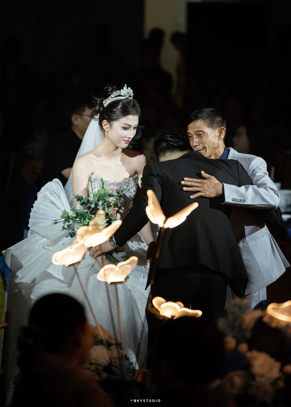Artistic night shot of couple surrounded by glowing lights during wedding celebration.