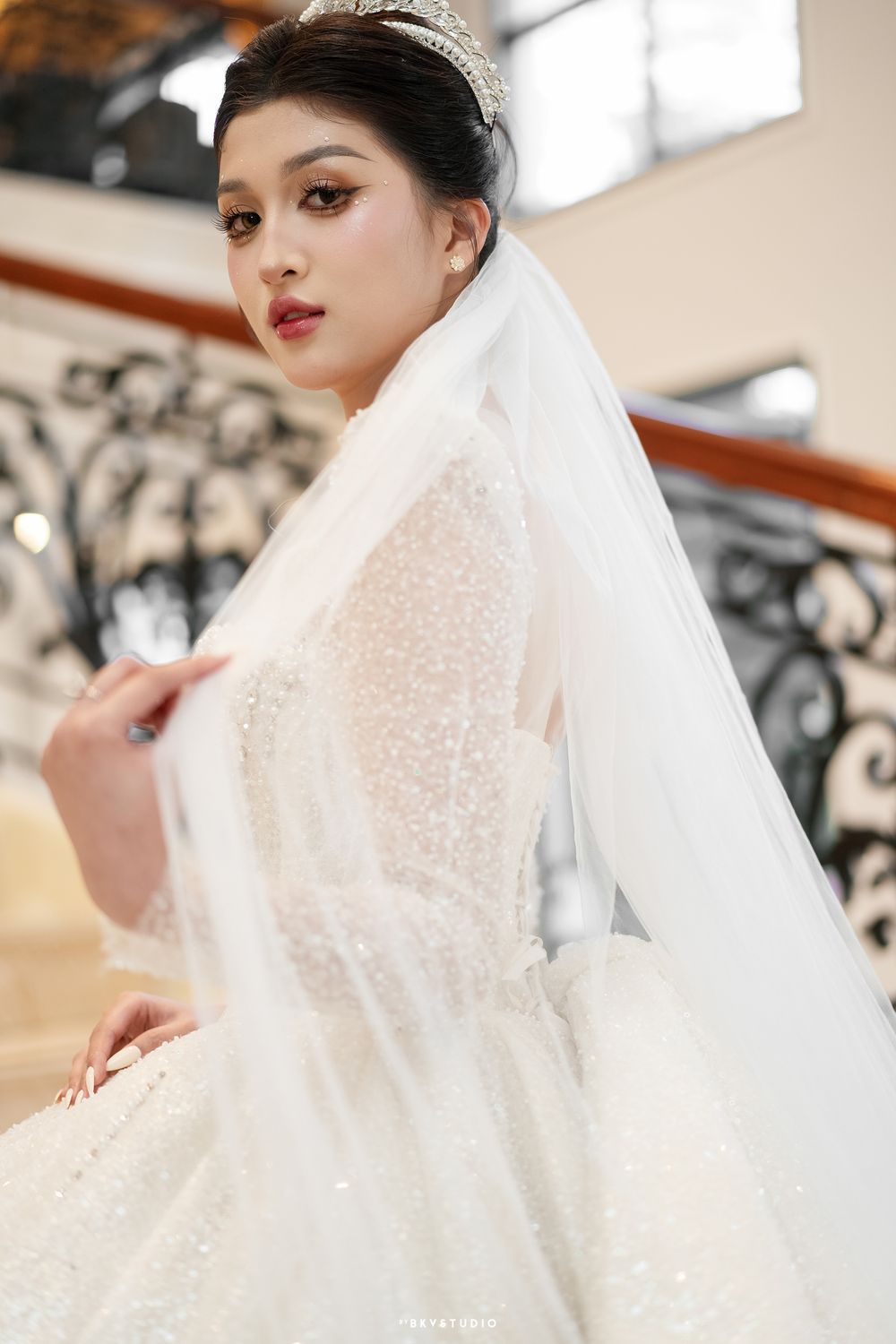 Close-up bridal portrait showing intricate lace detail and flowing veil.