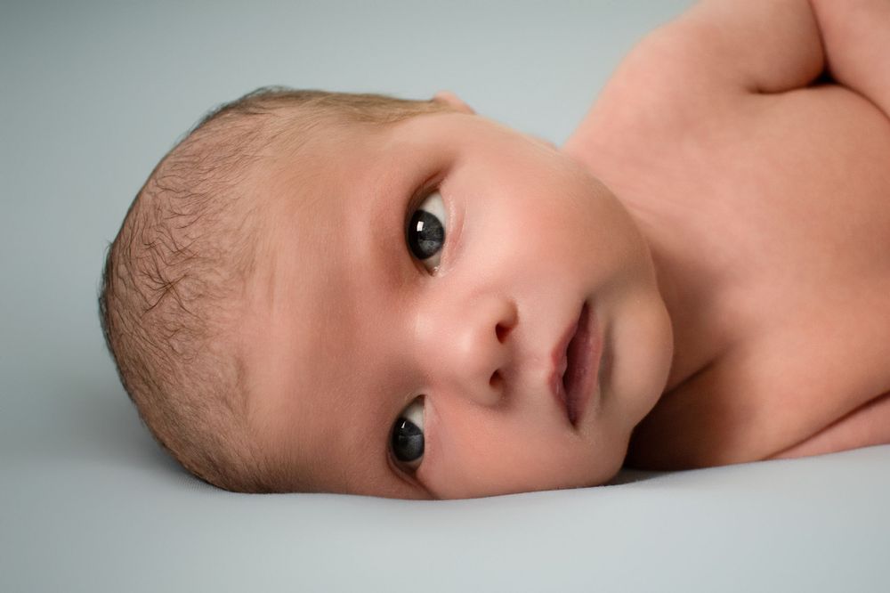 Sweet baby portrait with soft lighting on light background captures peaceful innocence creative newborn portrait studio boiling springs sc