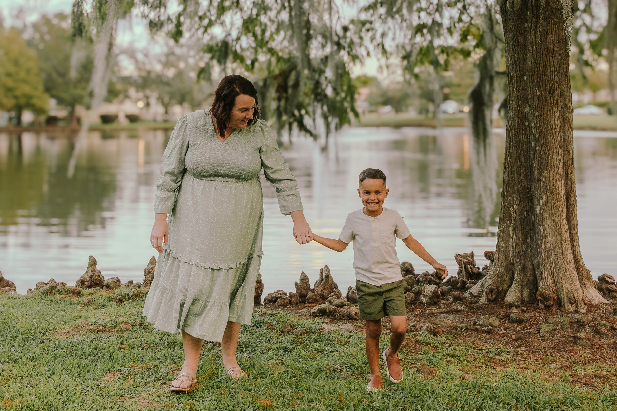 Family members standing together under trees near a waterfront.
