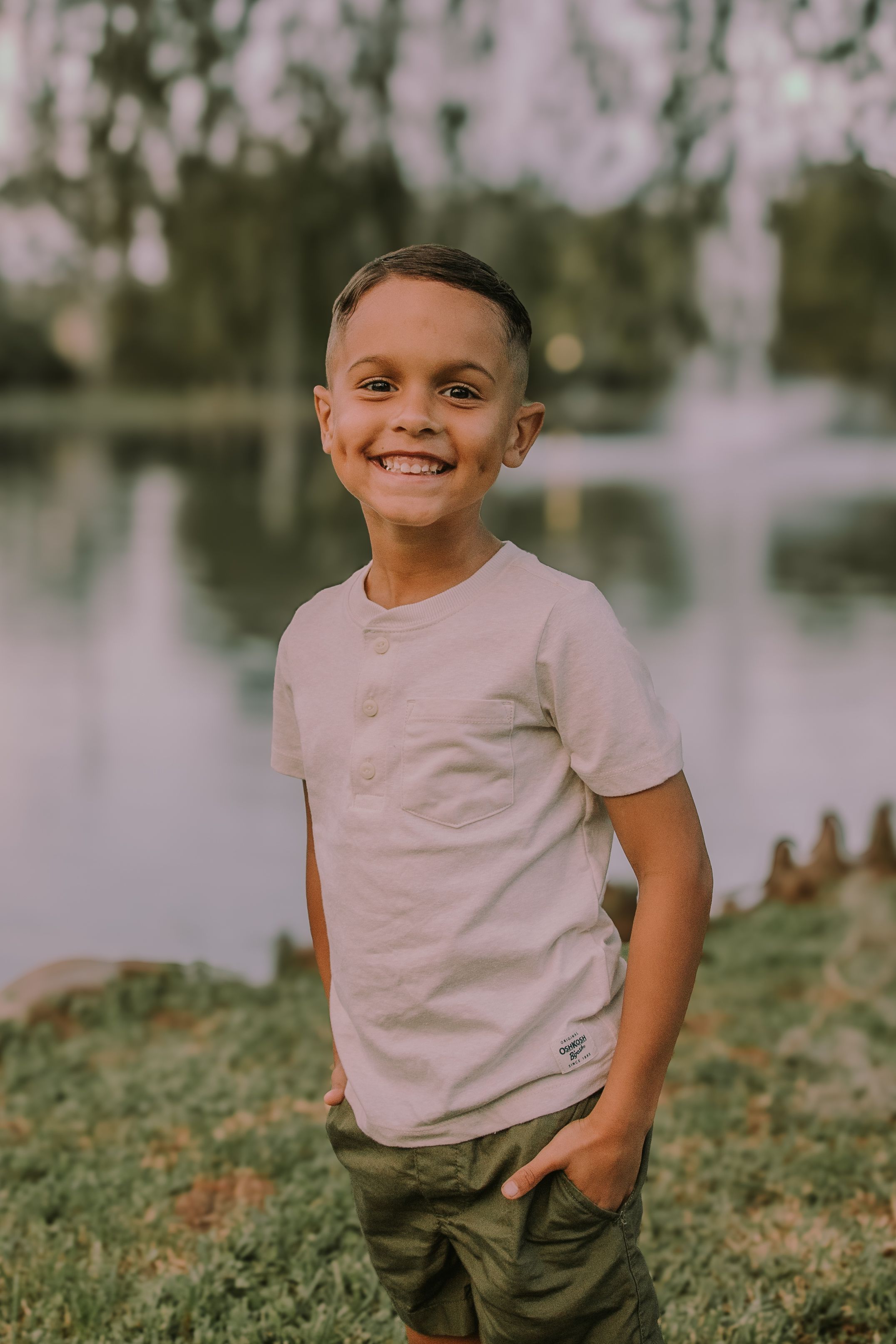 Child posing outdoors with a bright smile against a natural background.