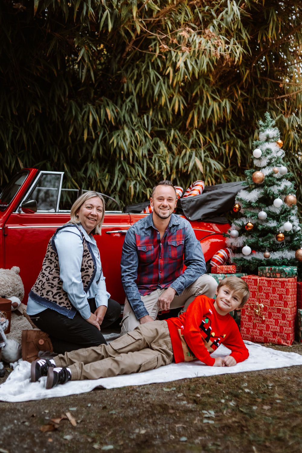 Mini-session photo de Noël 2024 avec une coccinelle VW rouge décorée pour les fêtes, créant une ambiance festive et chaleureuse.