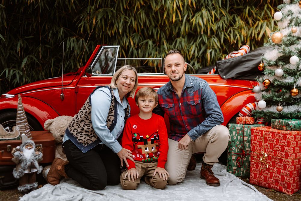Mini-session photo de Noël 2024 avec une coccinelle VW rouge décorée pour les fêtes, créant une ambiance festive et chaleureuse.