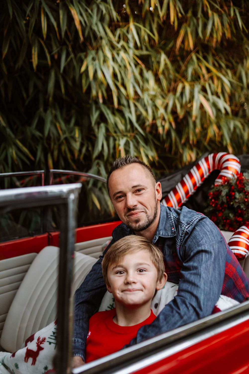 Mini-session photo de Noël 2024 avec une coccinelle VW rouge décorée pour les fêtes, créant une ambiance festive et chaleureuse.