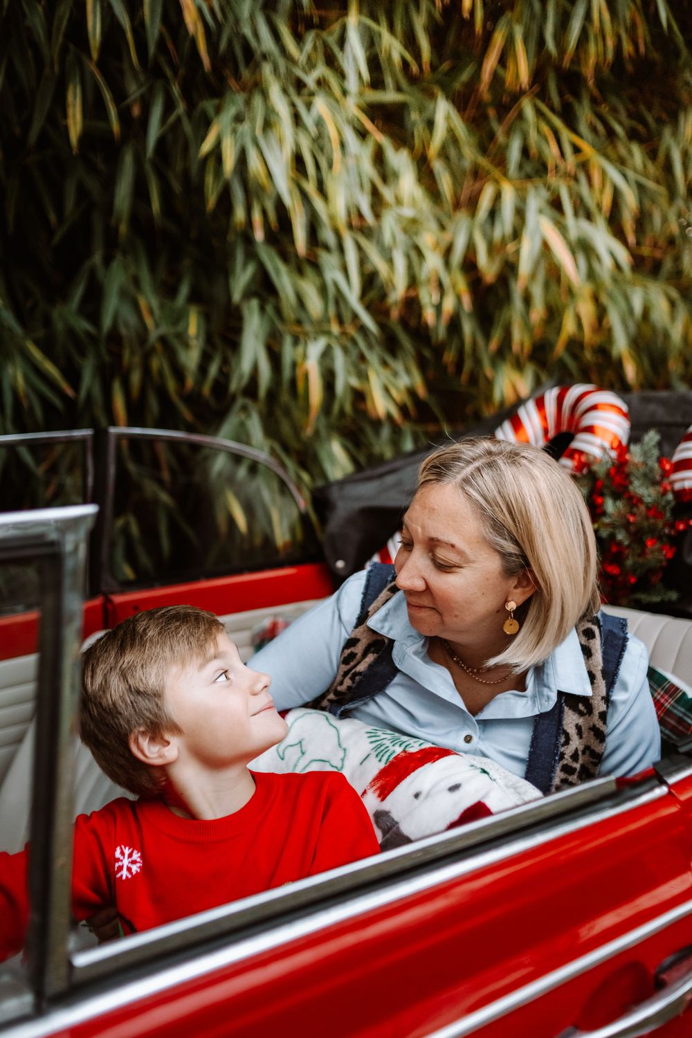 Mini-session photo de Noël 2024 avec une coccinelle VW rouge décorée pour les fêtes, créant une ambiance festive et chaleureuse.