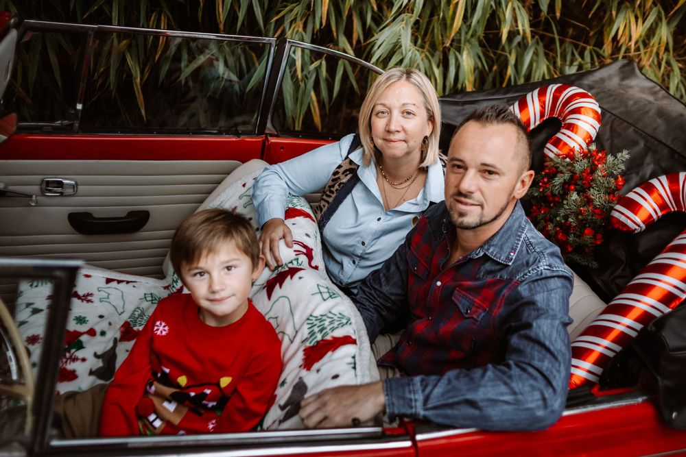 Mini-session photo de Noël 2024 avec une coccinelle VW rouge décorée pour les fêtes, créant une ambiance festive et chaleureuse.
