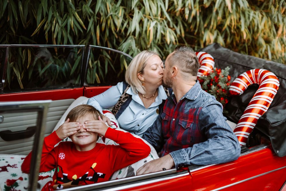 Mini-session photo de Noël 2024 avec une coccinelle VW rouge décorée pour les fêtes, créant une ambiance festive et chaleureuse.