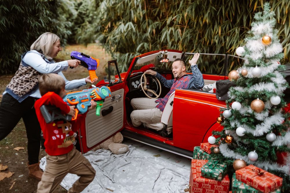 Mini-session photo de Noël 2024 avec une coccinelle VW rouge décorée pour les fêtes, créant une ambiance festive et chaleureuse.