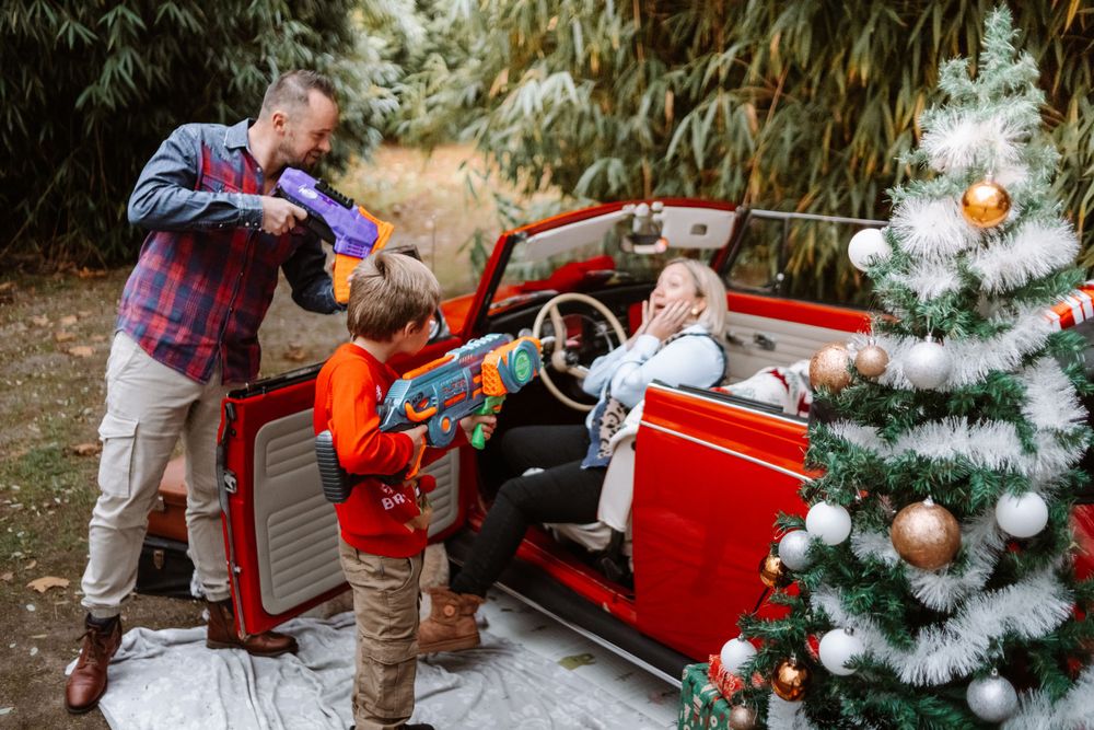 Mini-session photo de Noël 2024 avec une coccinelle VW rouge décorée pour les fêtes, créant une ambiance festive et chaleureuse.
