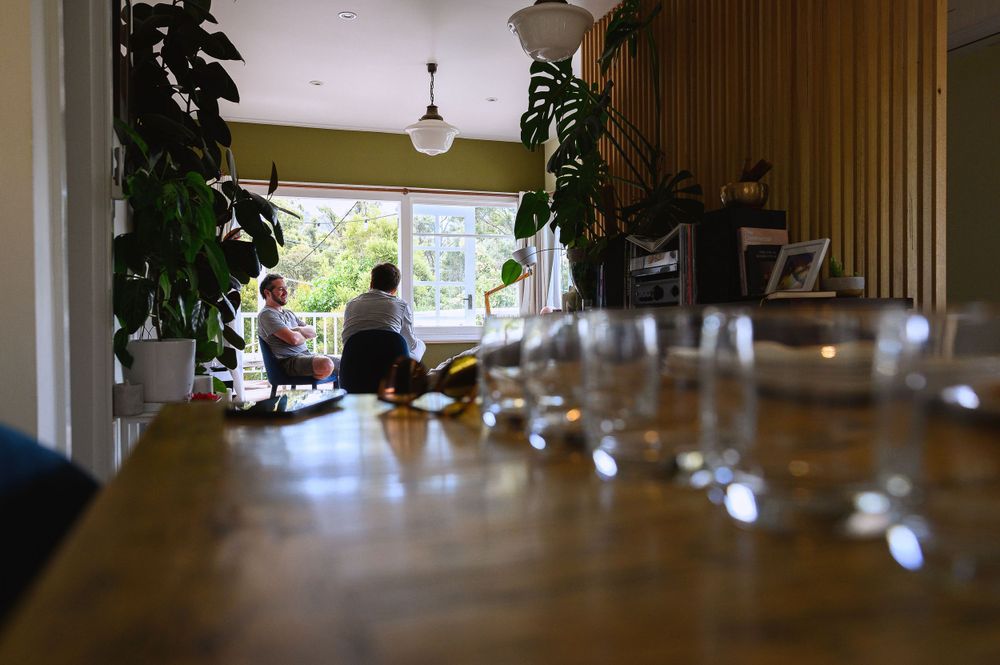 Interior view of dining room with wine glasses and indoor plants in warm lighting.