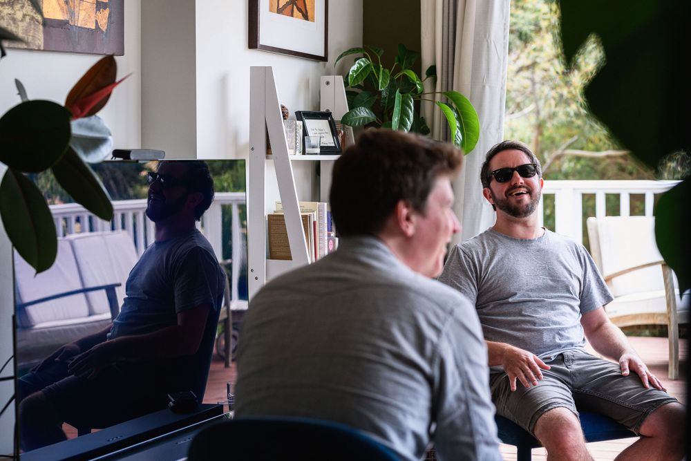 Casual indoor gathering with people sitting and chatting in a bright room.