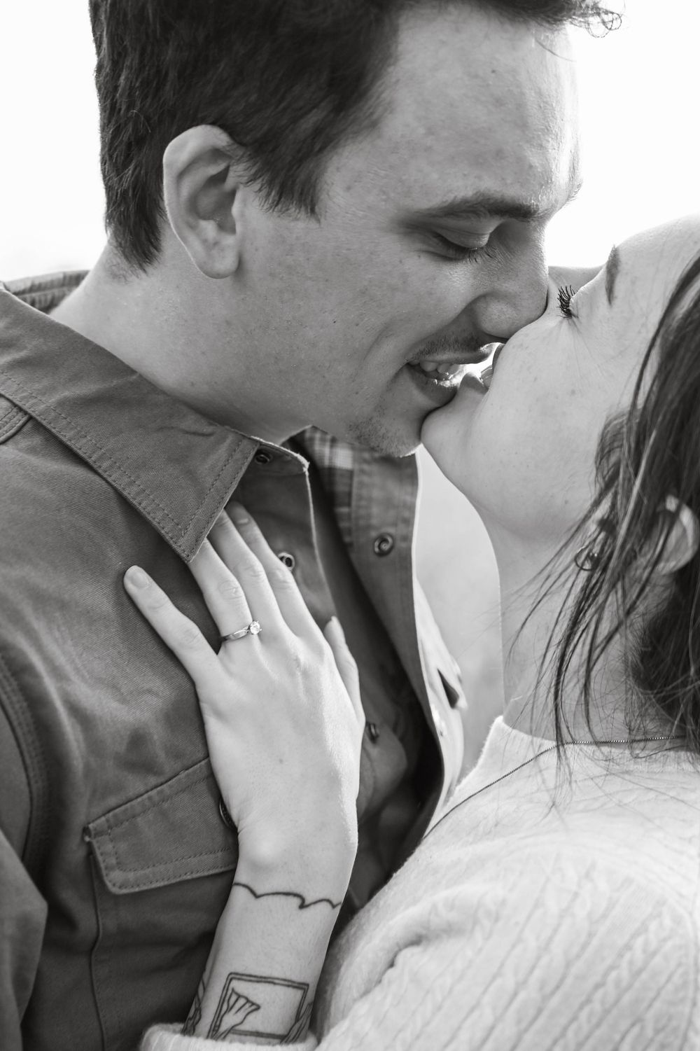 Intimate black and white portrait of engaged couple sharing romantic moment.