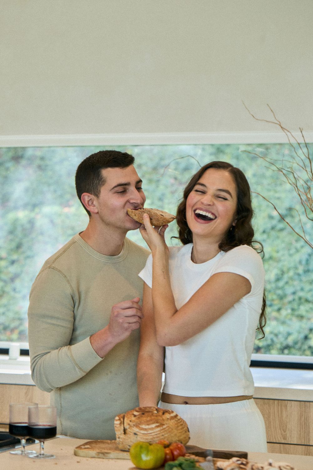A couple shares a joyful moment together in the kitchen while enjoying pastries.