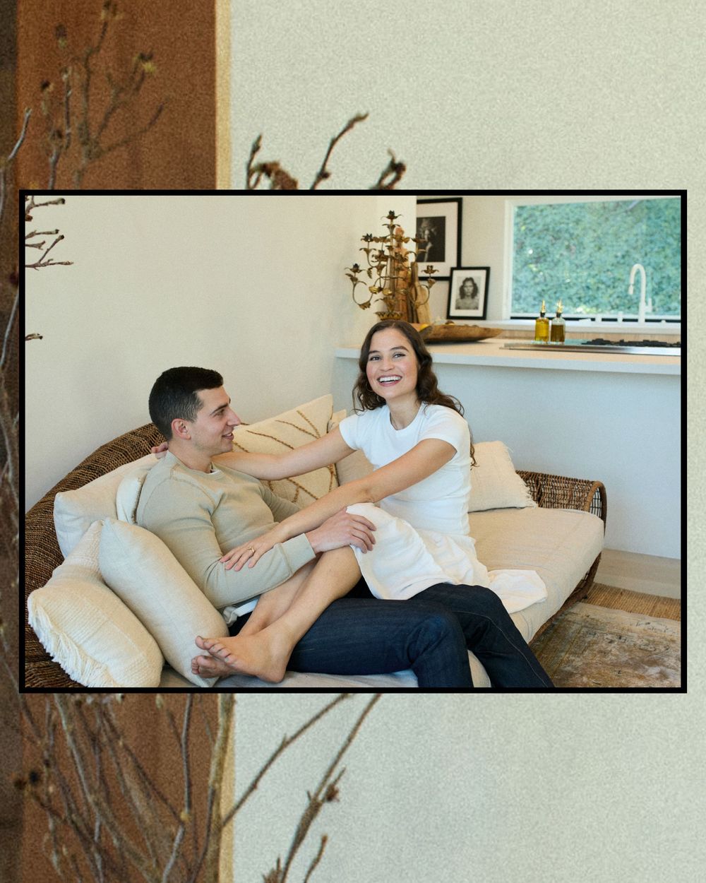 A couple relaxes together on a beige couch in a cozy living room with natural decor elements.