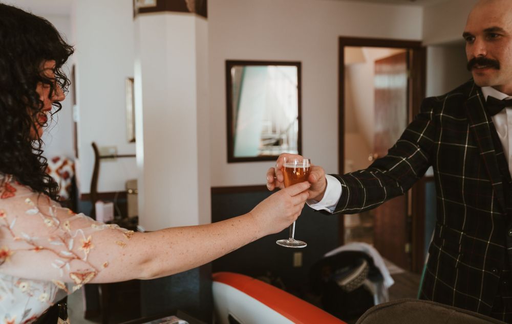 Celebratory champagne toast between two people in formal attire.