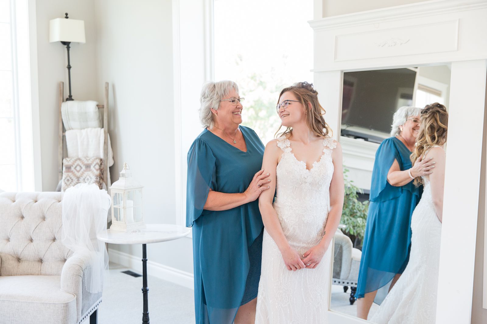A touching moment in a bright white room with bridesmaids preparing for a wedding ceremony.