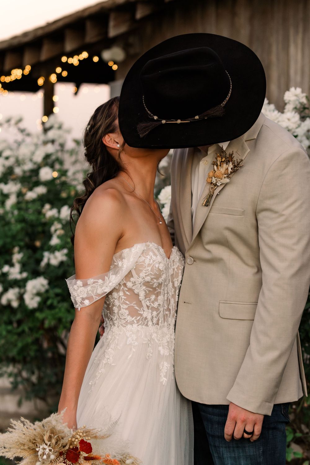Close-up wedding photos showing details of lace dress and tan suit against rustic backdrop.