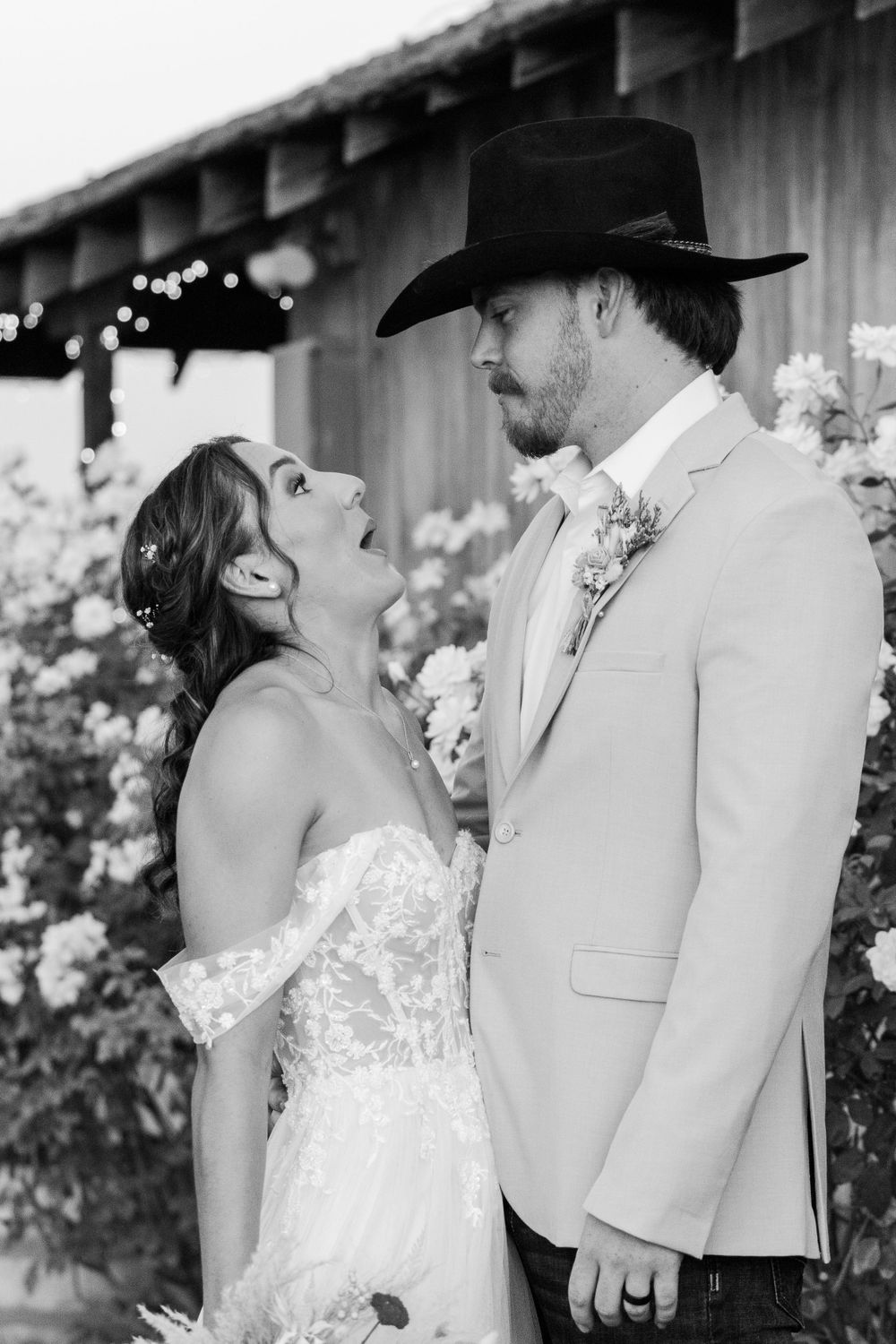 Intimate wedding couple portraits with rustic barn backdrop and twinkling lights.
