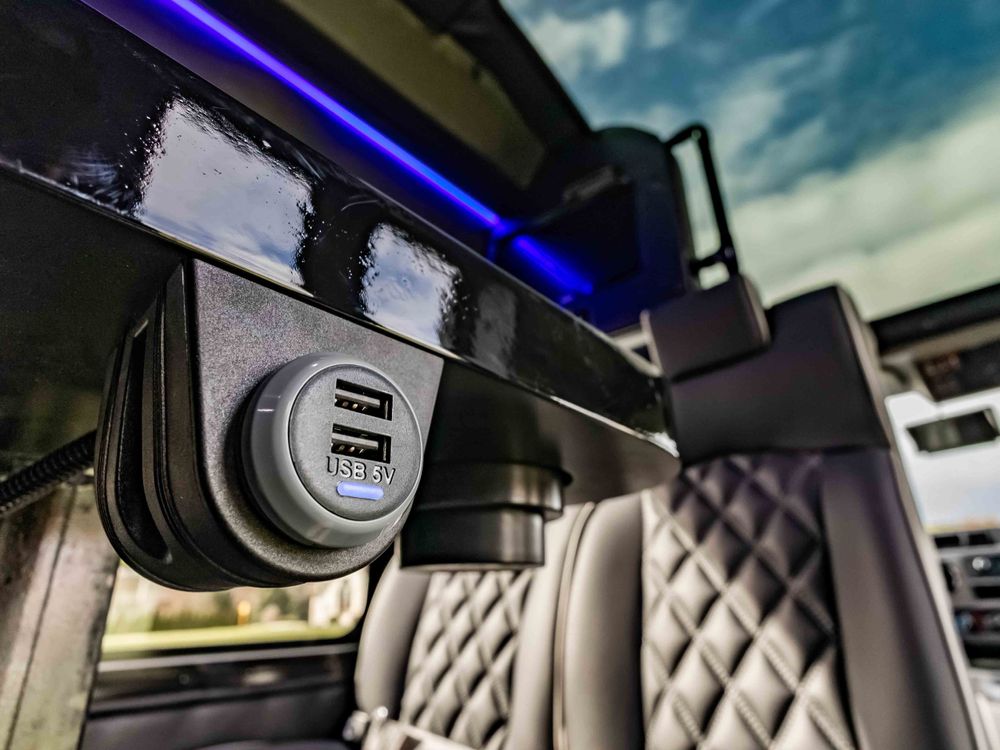 Luxury vehicle USB charging port with blue LED accent lighting.