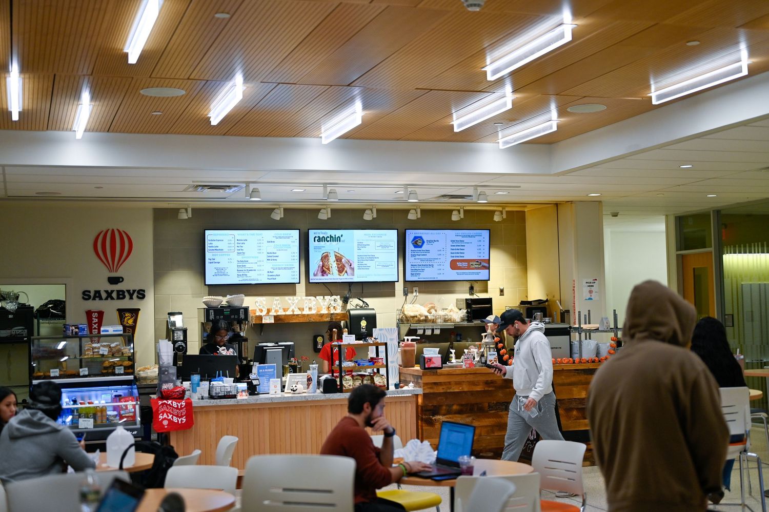 Interior view of a Saxbys cafe showing the service counter, menu displays, and seating area.