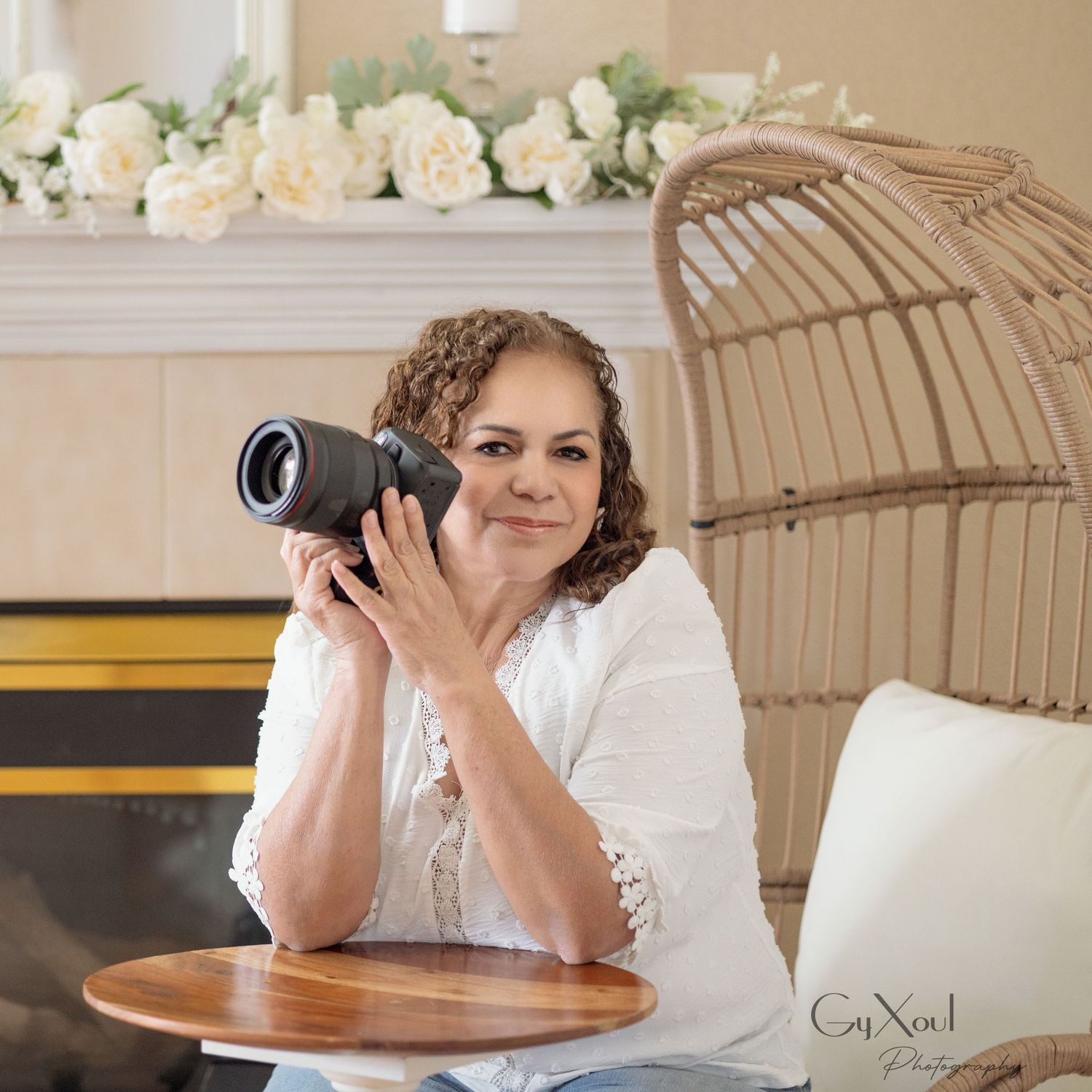 Professional photographer wearing black Gyxoul shirt taking photos with DSLR camera.