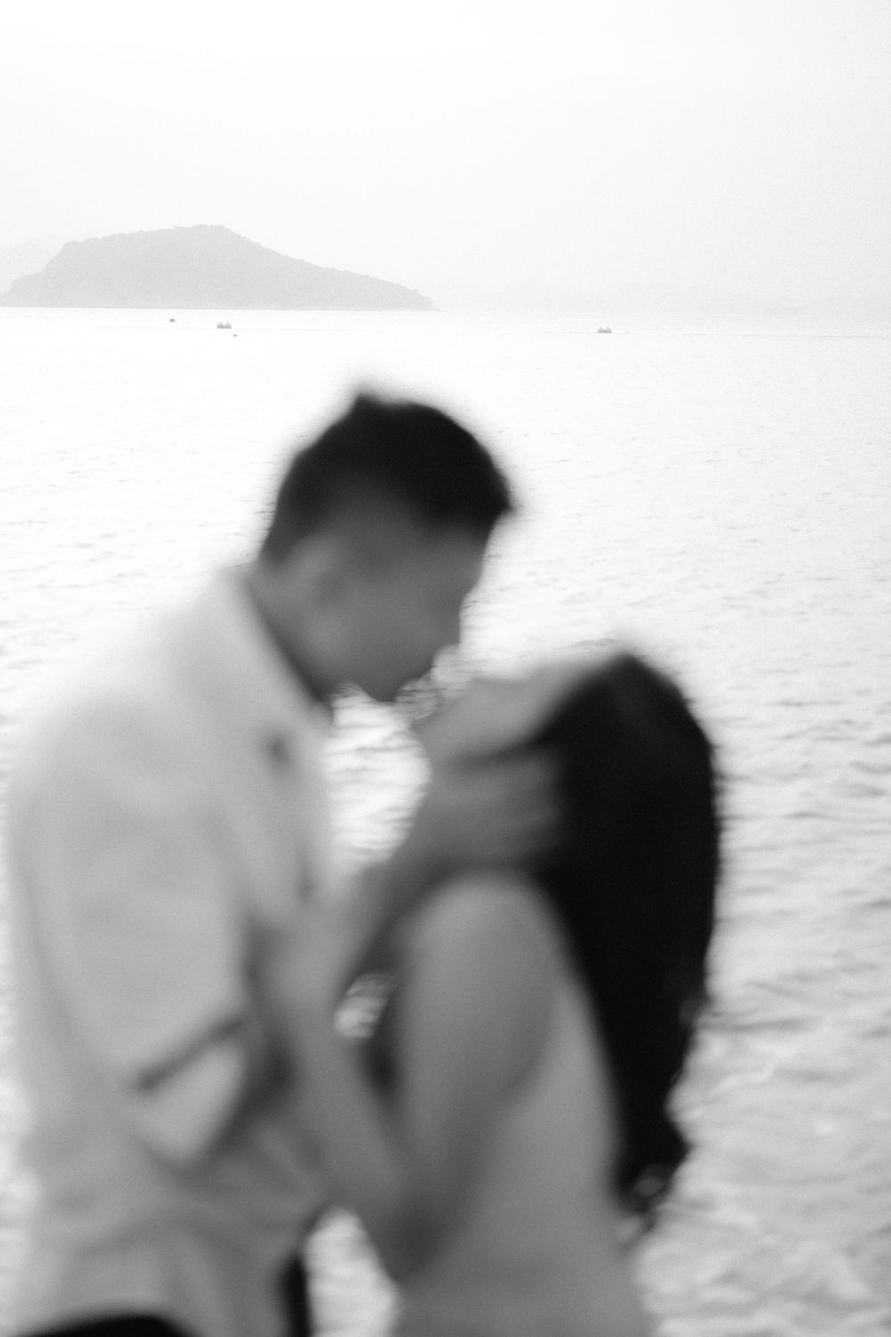 A black and white photo sequence shows a couple embracing and kissing by the ocean.