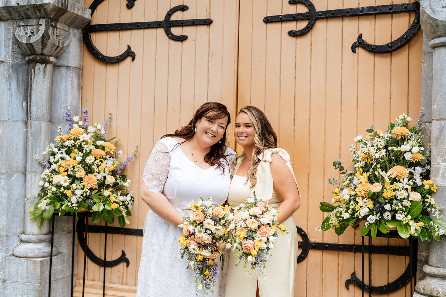 A happy celebration at a rustic barn venue decorated with white and yellow flowers and decorative horseshoes.
