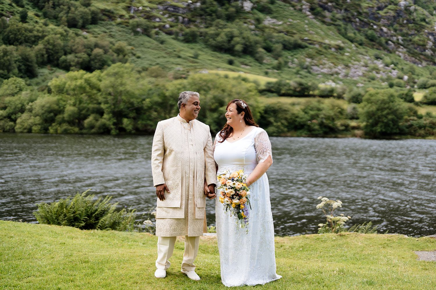 A couple shares intimate moments together against scenic mountain and lake backdrops in romantic outdoor photo series.
