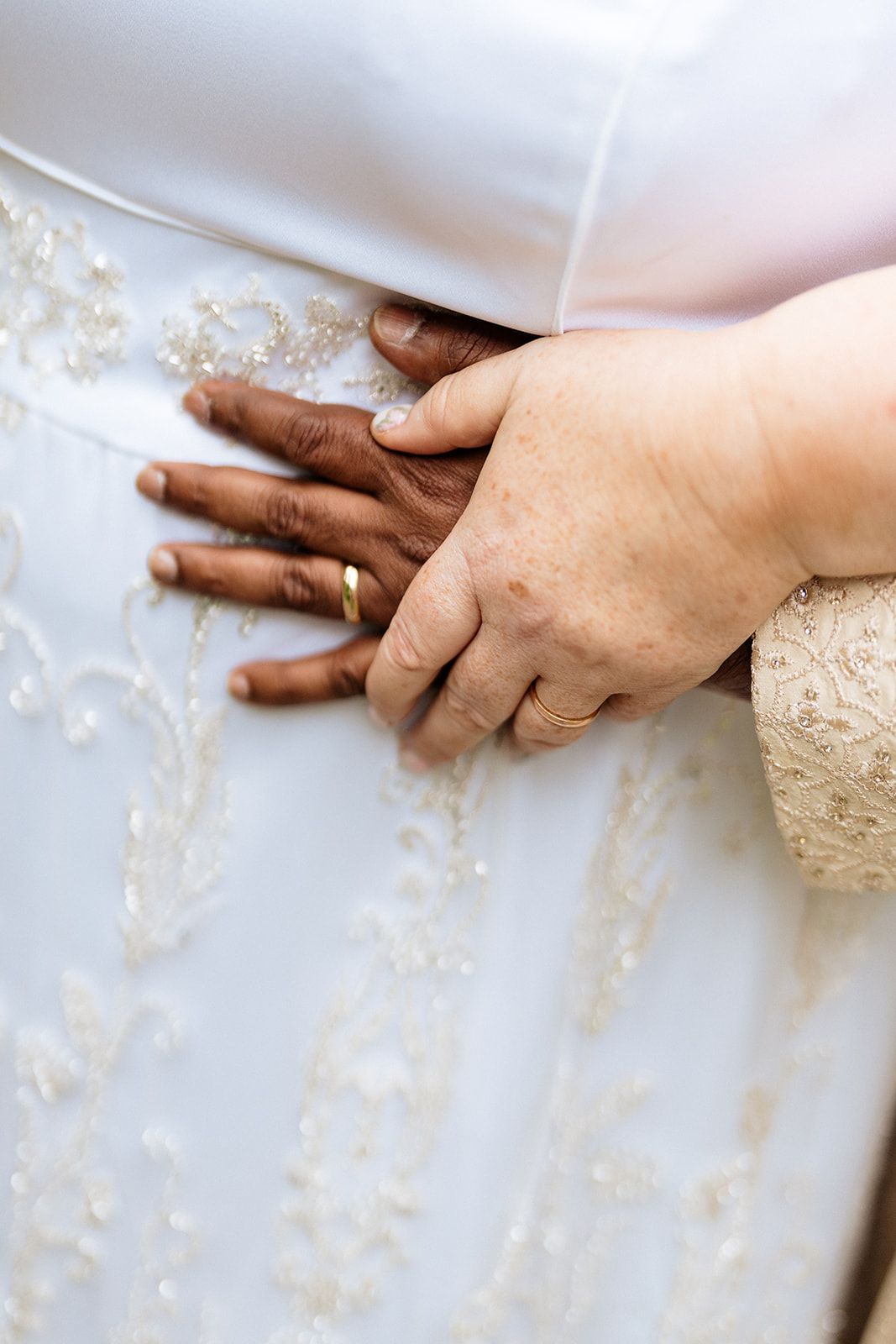 Close-up hands kneading dough on a floured white surface showing step-by-step bread making process.