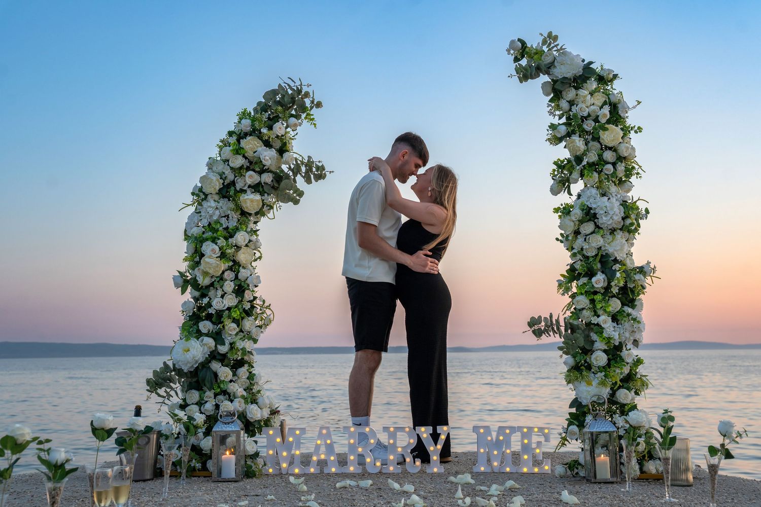 Proposal at the beach with sunset in Split Podstrana Croatia with flower arch