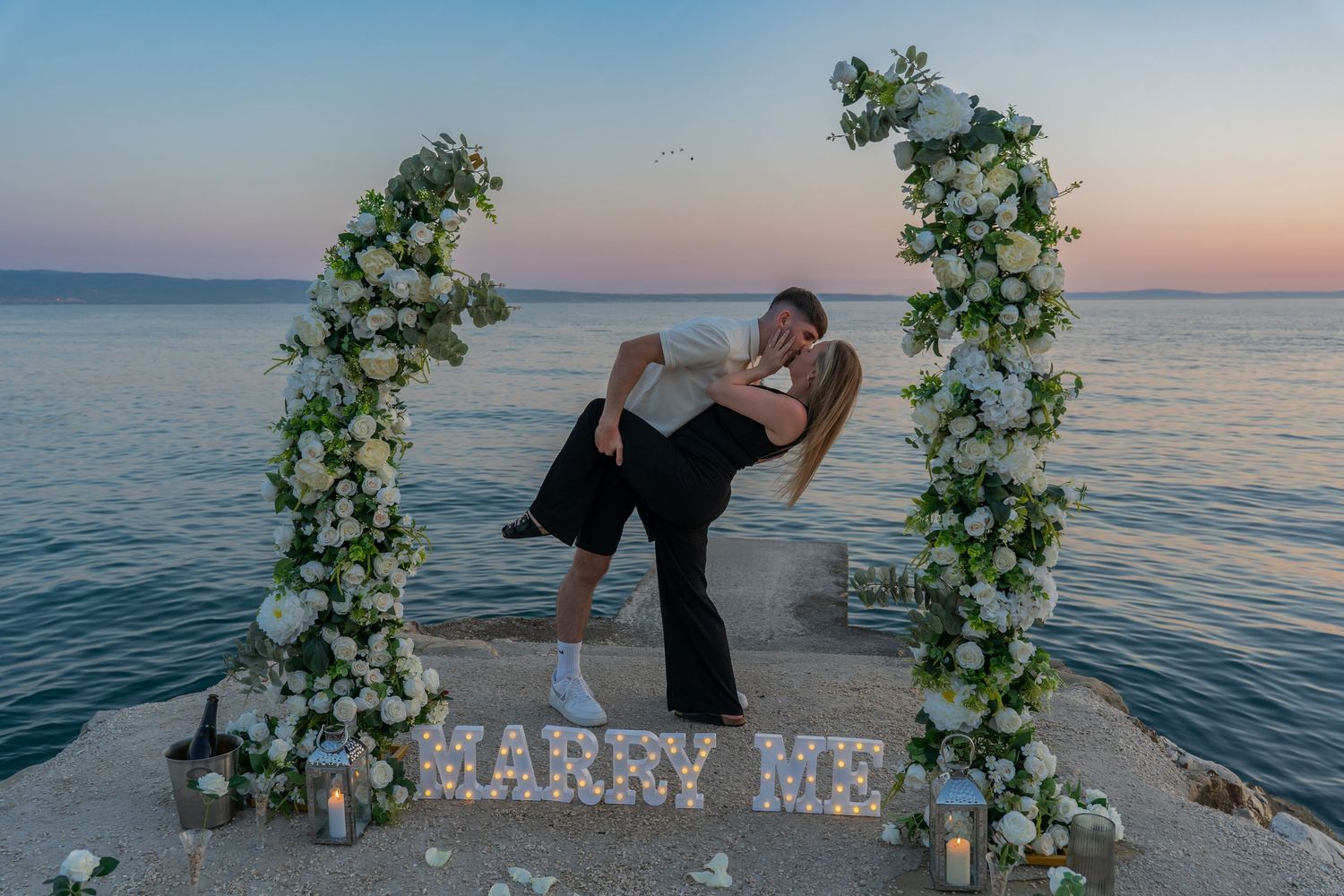 Proposal at the beach with sunset in Split Podstrana Croatia with flower arch