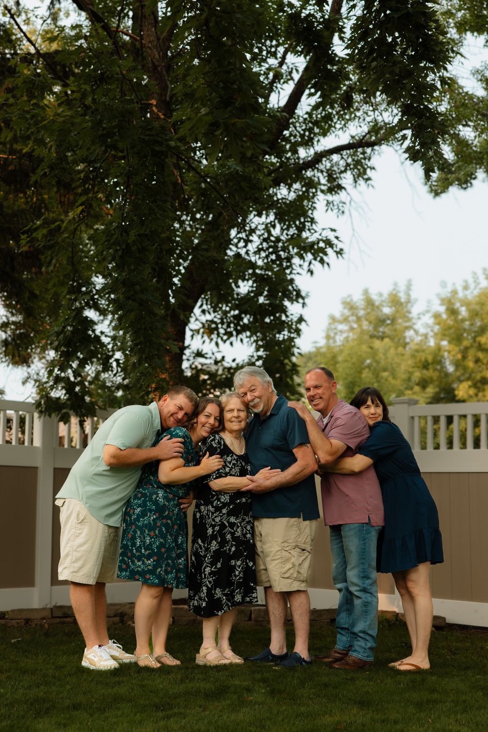 A creative photo sequence showing people standing in a line and bending down in a coordinated wave motion on a lawn.